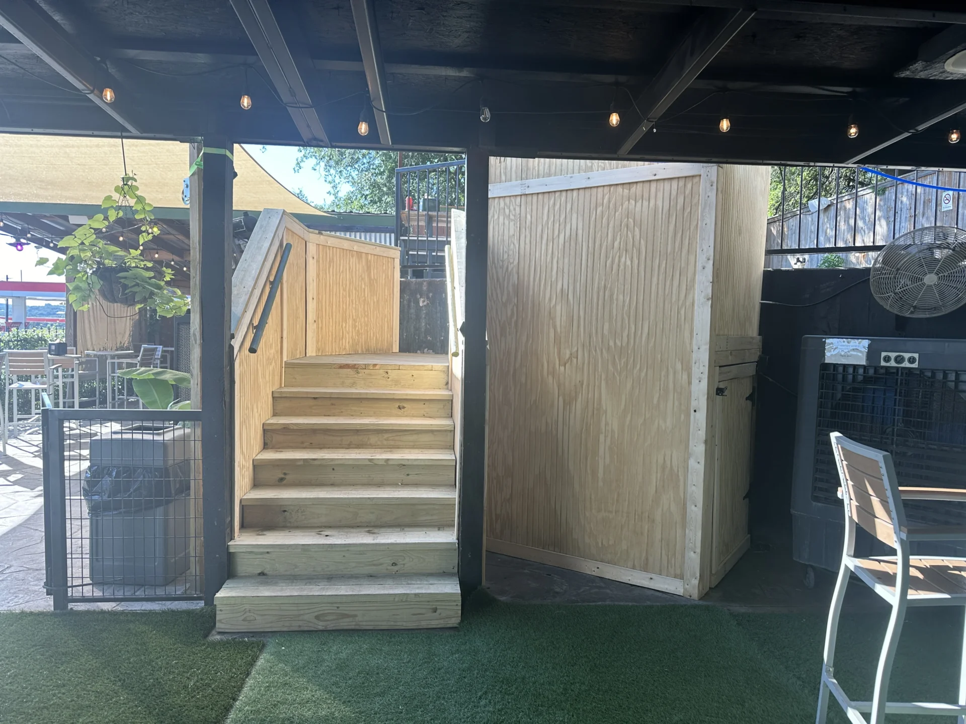 Outdoor patio with wooden stairs and seating.